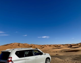 Go on Errachidia desert Tour with a white SUV car in Sahara desert sand dunes