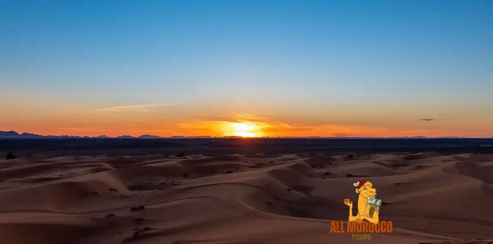 Breathtaking Merzouga Sahara sunset caps off a day on the 5 days desert tour from Fes to Marrakech with the-sun dipping below the horizon casting vibrant hues over the serene dunes