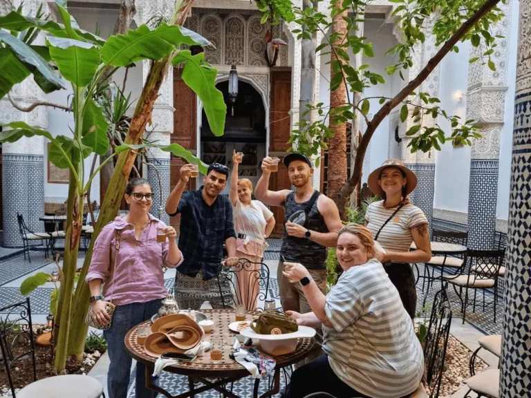 Best Fes Tours with travelers enjoying Moroccan tea in a traditional riad