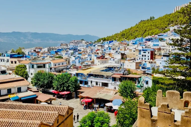 anoramic view of Chefchaouen’s blue and white buildings, historic kasbah and surrounding Rif Mountains